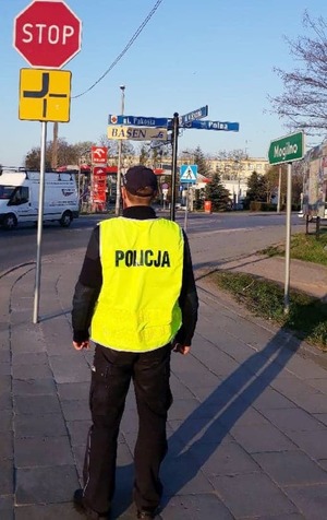 policjant stoi przy skrzyżowaniu ulic