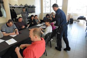 policjant rozdaje mieszkańcom gminy ankiety