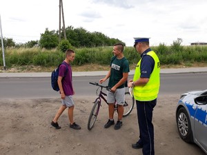 policjant rozmawia z młodymi rowerzystami