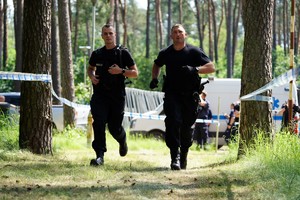 Dwóch policjantów biegnących po torze przeszkód