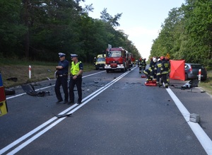 Wypadek drogowy na DK 80, na pierwszym planie policjanci za nimi wóz strażacki, karetka i rozbity citroen
