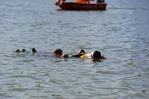 Jeden pies holuje w wodzie trzy poszkodowane osoby