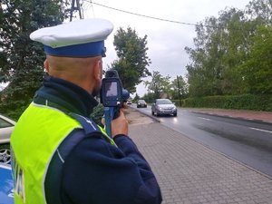 Policjant drogówki mierzy prędkość nadjeżdżającego auta