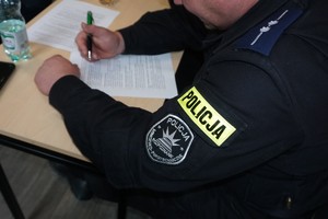 policjant pisze na kartce