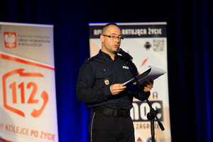 policjant prowadzi konferencję na scenie