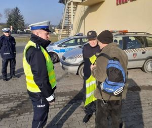 Policjant i strażnik gminny rozmawiają z pieszym