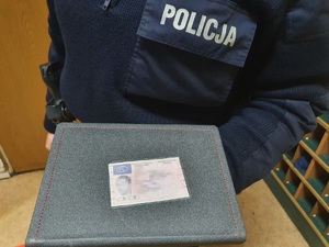 Policjant  eksponuje zalaminowaną kserokopie prawa jazdy
