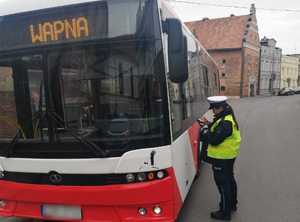 Policjantka kontroluje zatrzymany autobus
