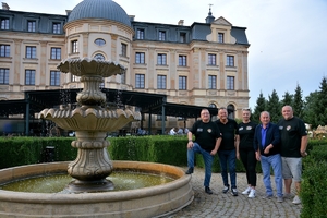 Grupa uczestników przy fontannie na tle Pałacu Bursztynowego