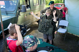 żołnierz zakłada chłopcu kamizelkę kuloodporną
