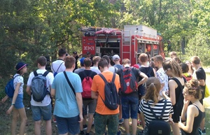 Uczniowie stoją przy pojeździe straży pożarnej.