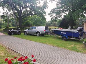 Policyjny quad, radiowóz oraz łódź motorowa zaparkowane w Pieczyskach.