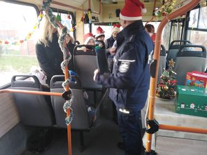 Policjant rozmawia z dziećmi w autobusie.