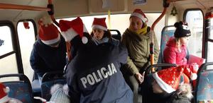 Policjantka z dziećmi i opiekunami w autobusie.