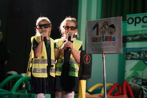 Dwie dziewczynki reprezentujące przedszkole podczas śpiewu na scenie.